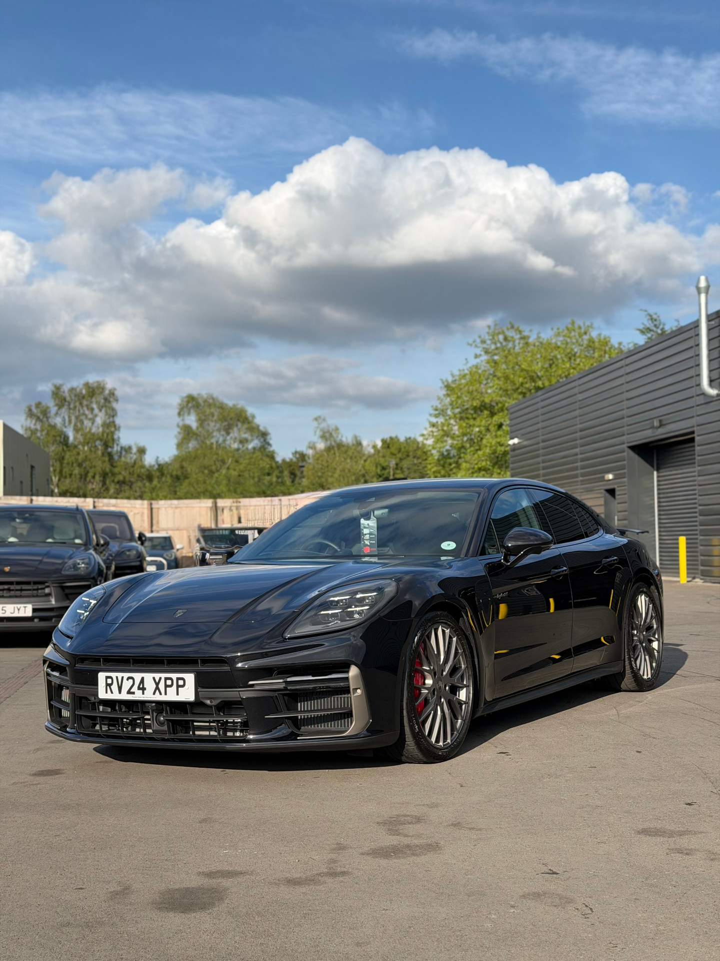 Black Porsche Panamera front three-quarter view outside studio