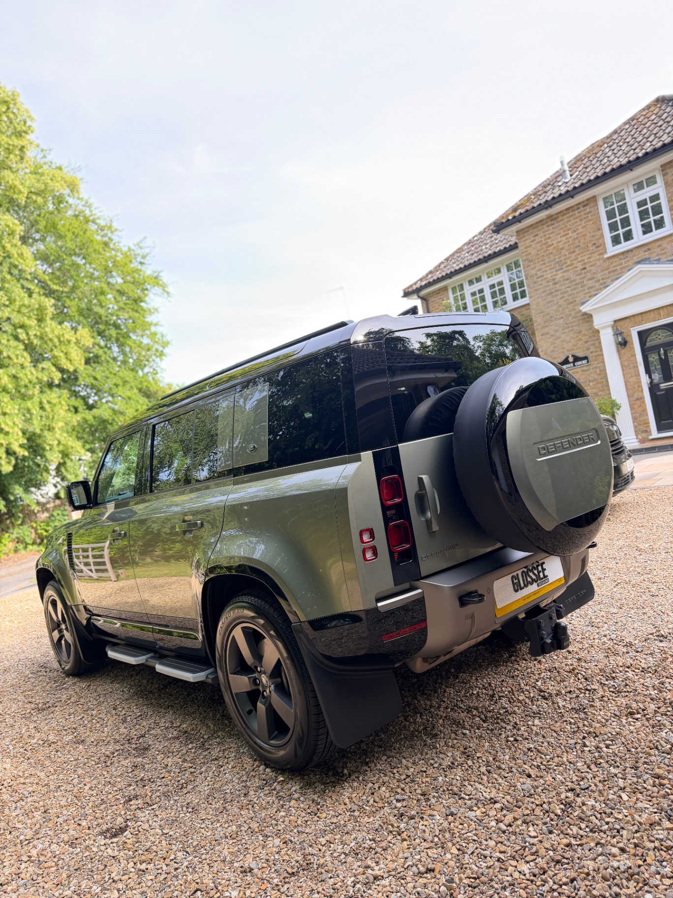 Satin green Land Rover Defender rear three-quarter view