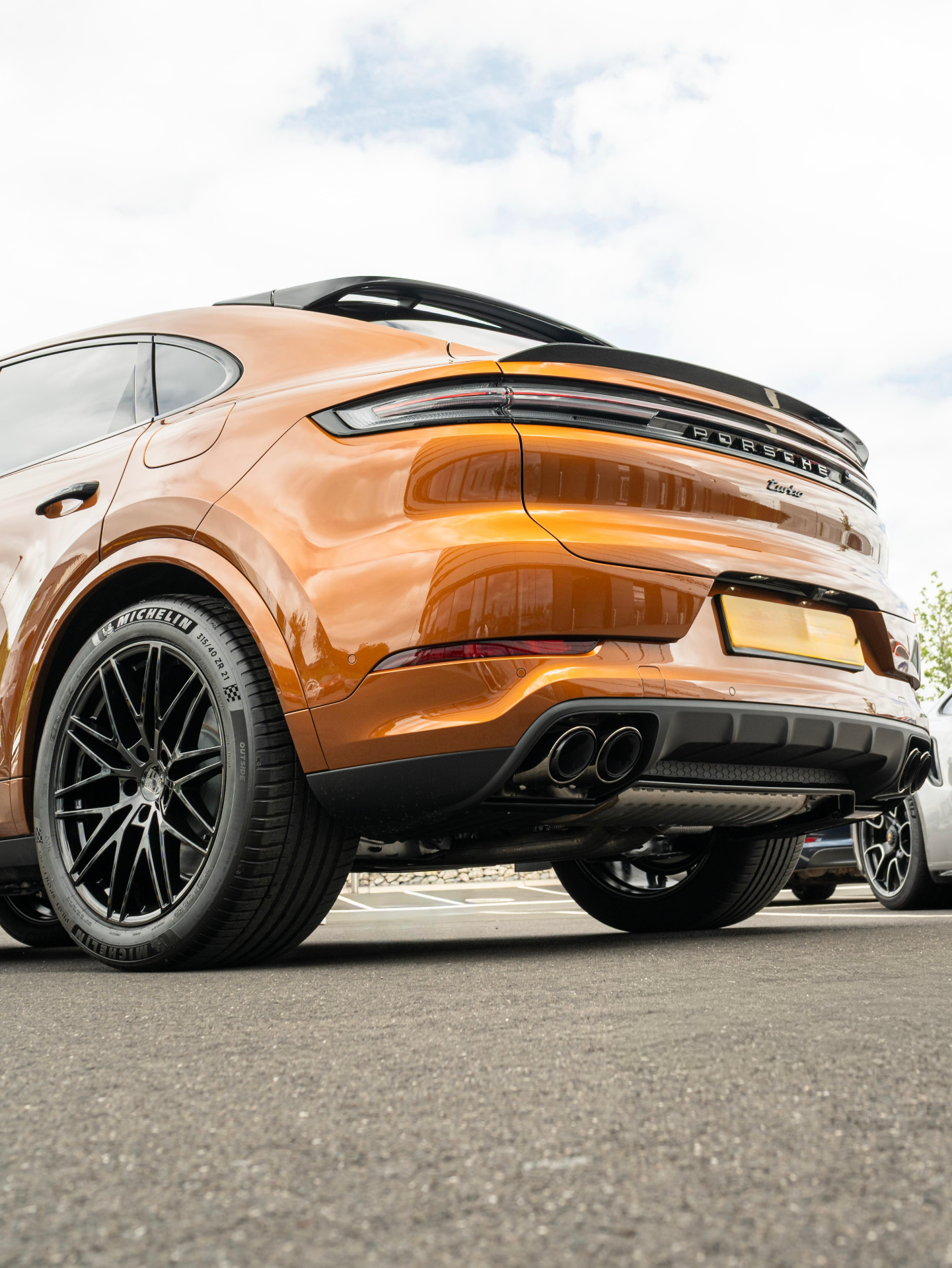 Orange Porsche Cayenne Coupe Turbo rear three-quarter view