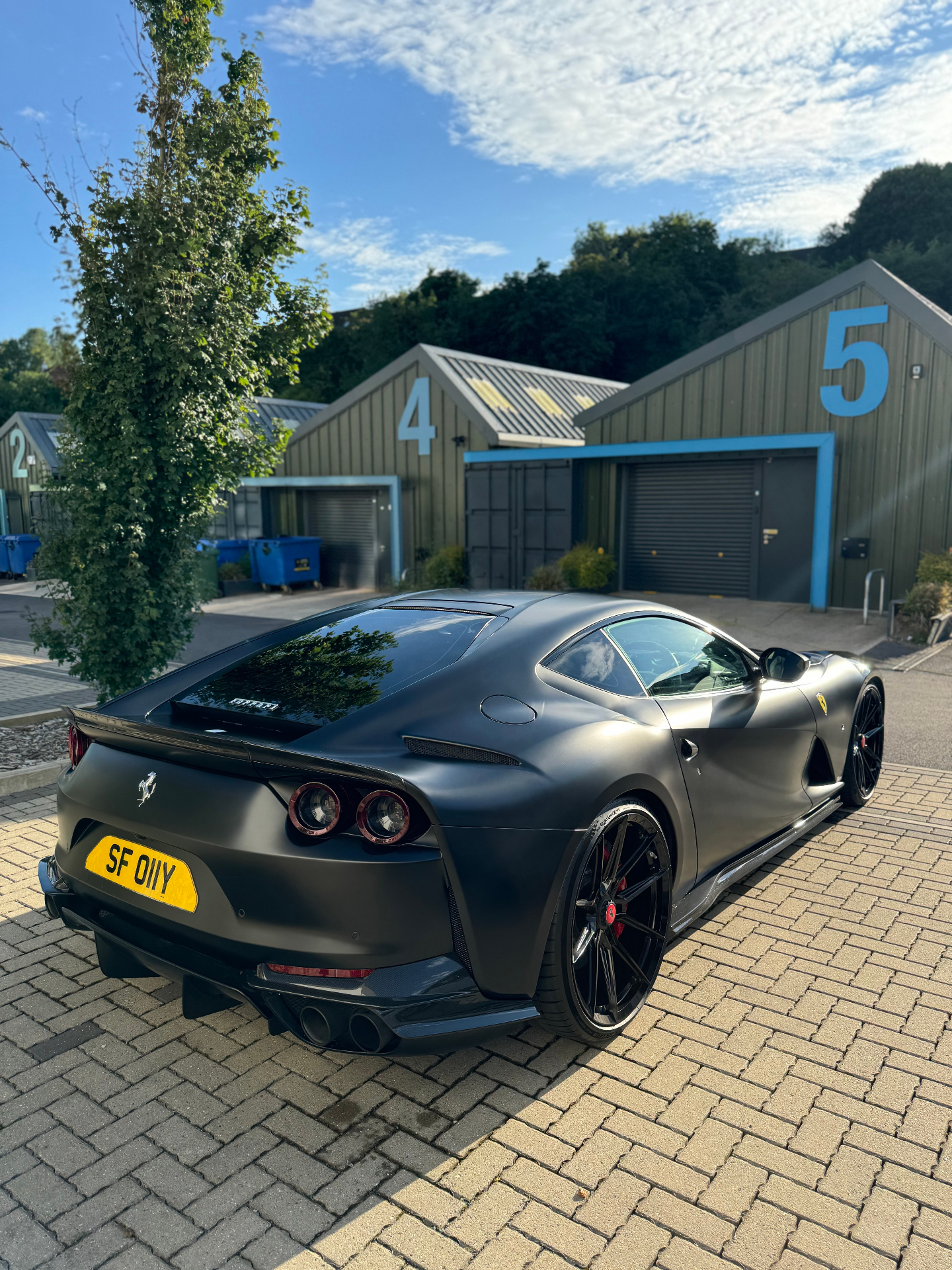Matte black Ferrari rear three-quarter view